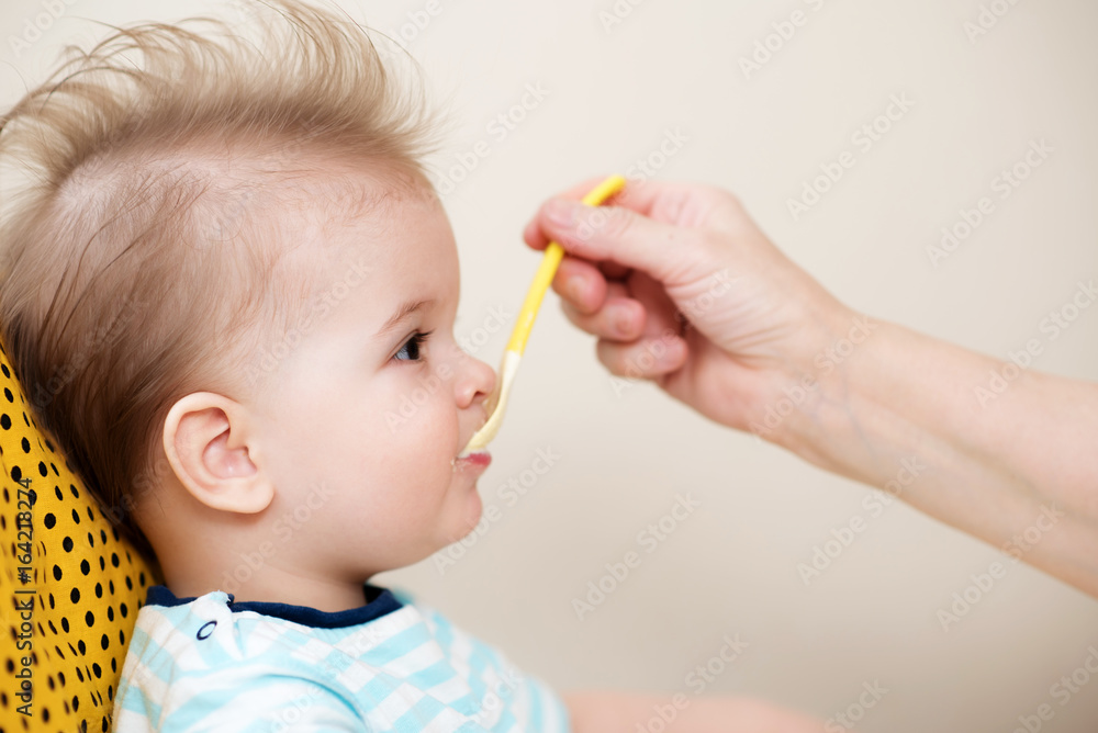 grandmother gives baby food from a spoon grandmother gives baby food from a spoon