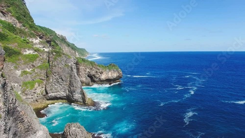 Fly near cliffed coast line and ocean. Bukit Peninsula Bali, Indonesia.
