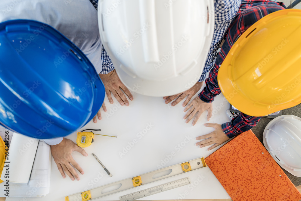 Group of young engineers or architects working in the office. engineers or architects meeting and planning project. Top view Group of young engineers or architects working in the office. engineers or architects meeting and planning project. Top view