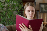 Teen woman read book chair inside