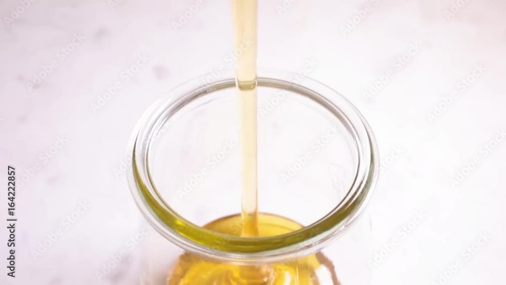 Honey poured into a glass tulip-shaped jar, viewed from above Honey poured into a glass tulip-shaped jar, viewed from above