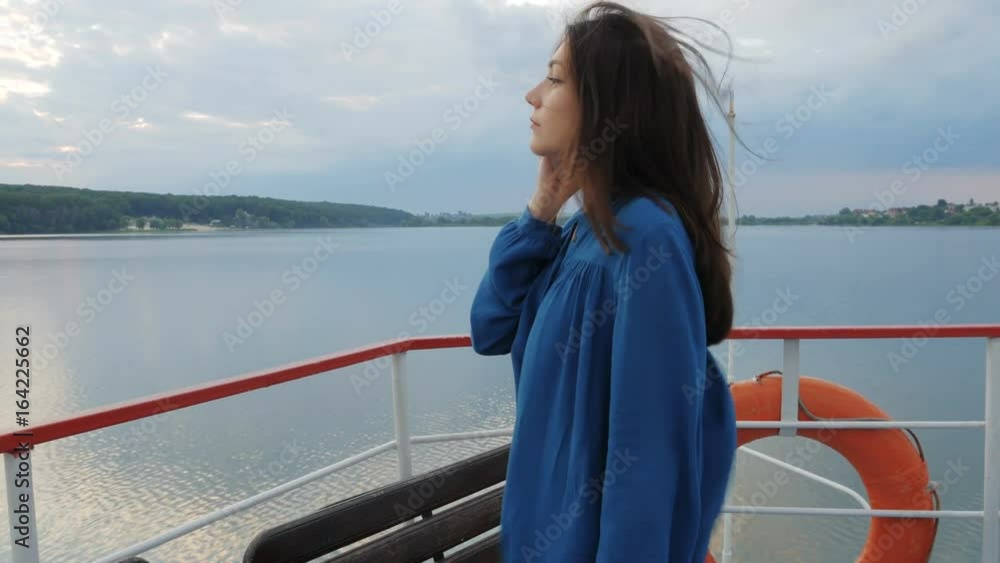 Travel, trip, vacation, tourist concept. Happy smiling young woman, female Asian mixed, traveling in a blue shirt, sailing on a passenger ship or boat in the summer on the lake sunset Travel, trip, vacation, tourist concept. Happy smiling young woman, female Asian mixed, traveling in a blue shirt, sailing on a passenger ship or boat in the summer on the lake sunset