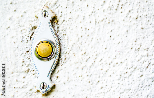 Fotografija weathered mid century doorbell and plate on house wall