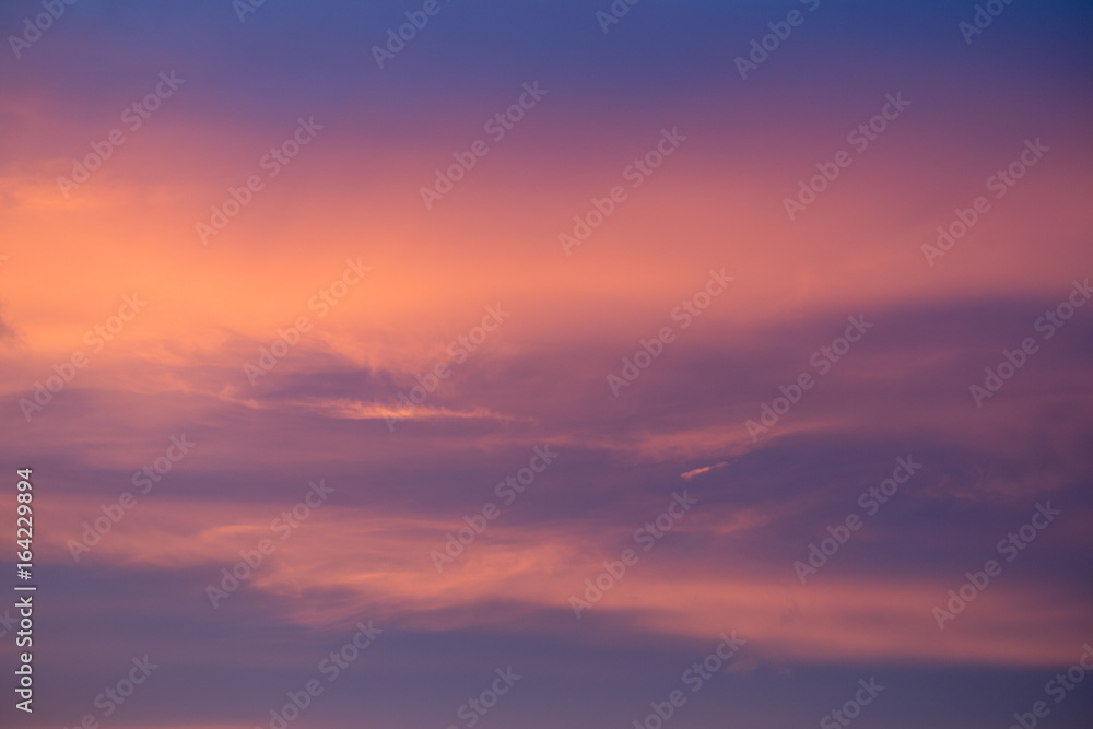 Warm pink glow in cold blue sky. Background empty blurred. Deep blue matte backdrop. Ruddy glow.