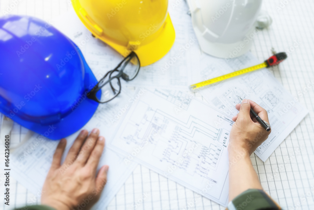 Engineer working on construction project,helmet and laptop on the table. Engineer working on construction project,helmet and laptop on the table.