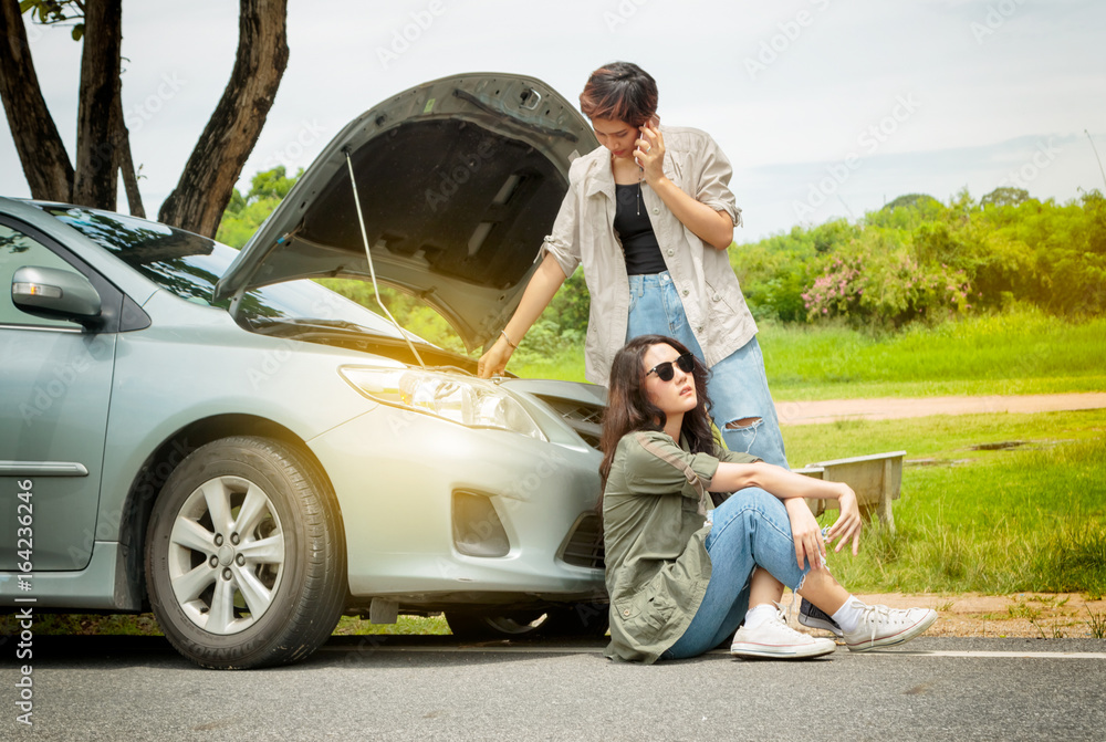 Woman calling the roadside service/assistance after her car has broken down Woman calling the roadside service/assistance after her car has broken down