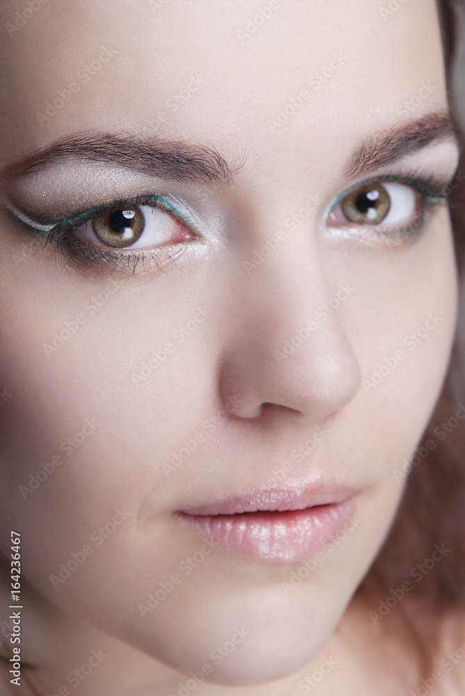 Close-up portrait of girl with clean skin and bright makeup. Demonstration of makeup cat eyes. Close-up portrait of girl with clean skin and bright makeup. Demonstration of makeup cat eyes.