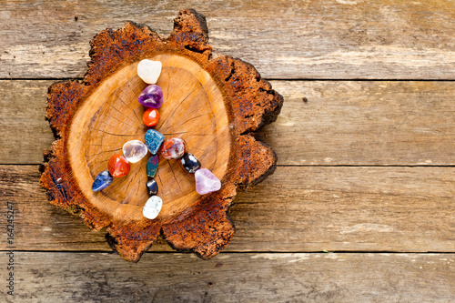 Peace symbol in crystals on circle of timber log against old textured wooden background