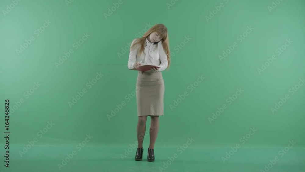 a young woman is calling on the phone and holding a clipboard a young woman is calling on the phone and holding a clipboard