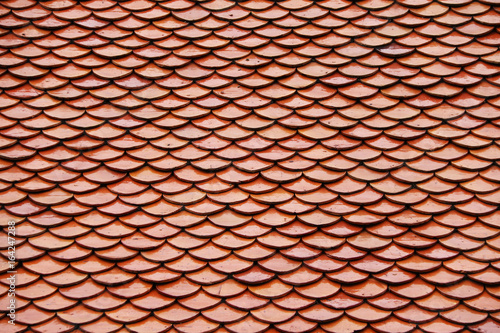 Pattern of Thai terracotta roof, red brown color. The pattern look like a fish scales.