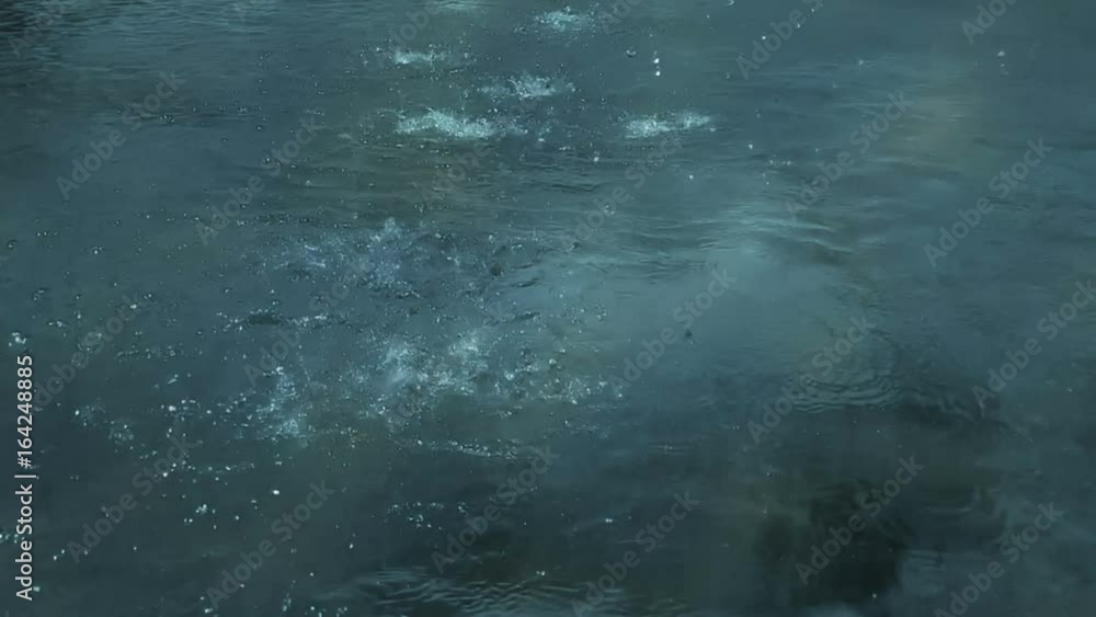 slow motion of heavy rain water drops or foutain on surface street, seamless loop ready slow motion of heavy rain water drops or foutain on surface street, seamless loop ready