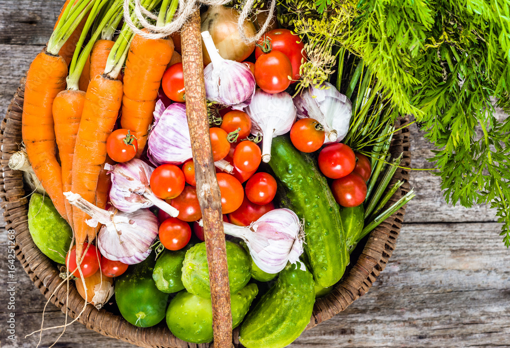 Colorful vegetables in basket, organic produce from farmer market on wooden table