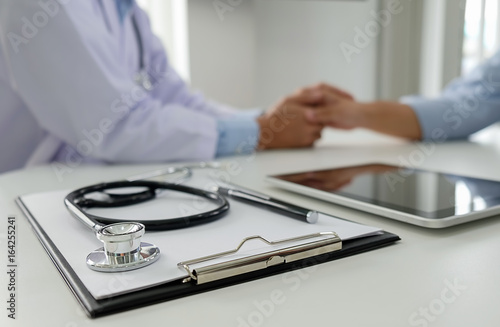 Stethoscope with clipboard and Laptop on desk, Doctor working in hospital writing a prescription, Healthcare and medical concept, test results in background, vintage color, selective focus.