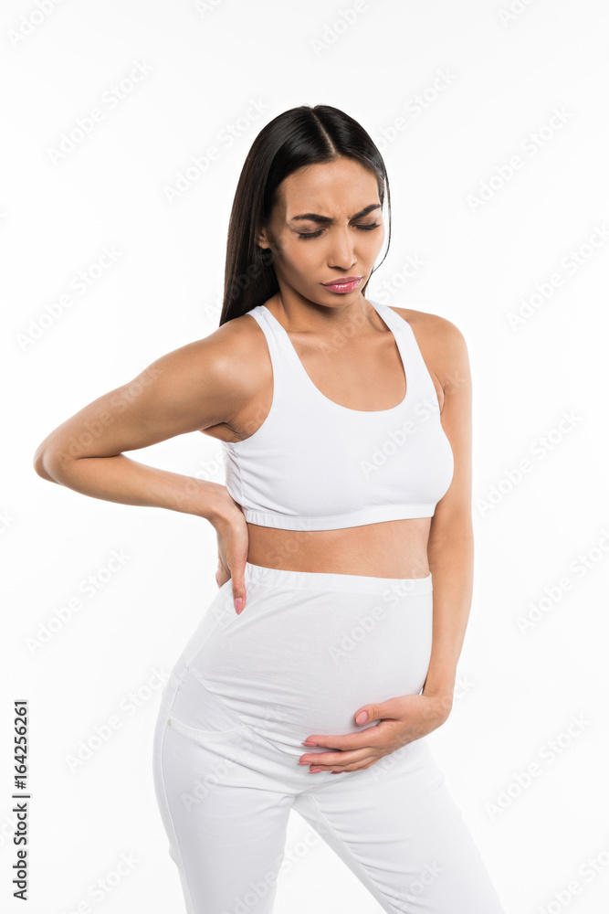 worried pregnant asian woman with pain touching her belly, isolated on white worried pregnant asian woman with pain touching her belly, isolated on white