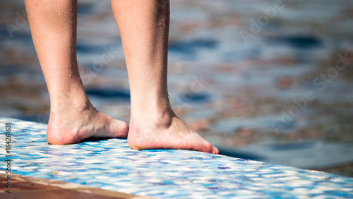 Feet of the girl near the pool © schankz