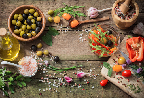 vegetables and olives on old wooden background