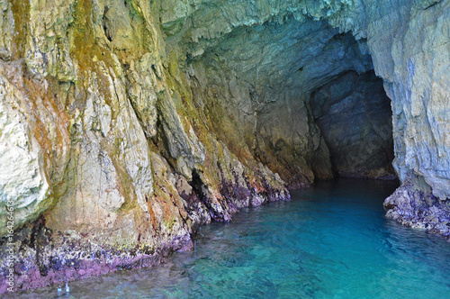 Green grotto with colourful walls and emerald water
