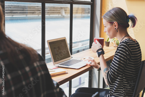 Two freelance working in coffee shop, Nomad worker conceptual, couple work together in cafe with laptop photo