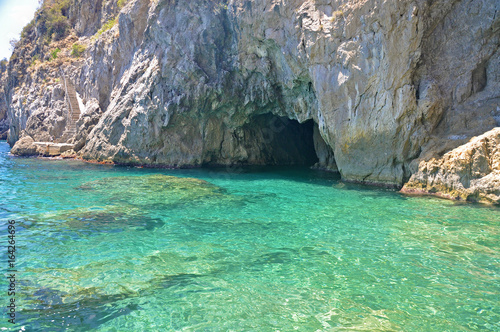 Entrance to the Green grotto with colourful walls and emerald water © Antonina