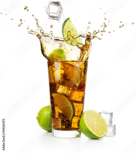 lime slice and ice cube falling into splashing cuba libre cocktail