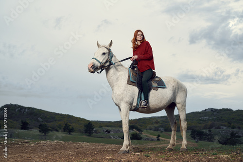 Beautiful young woman in the mountains walking with her horse © SHOTPRIME STUDIO