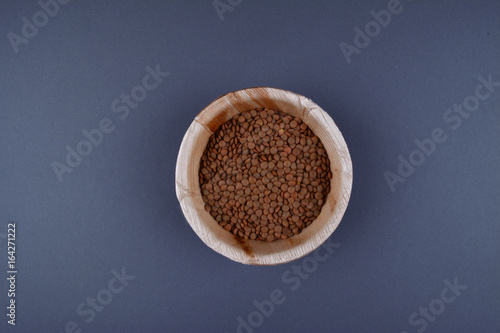 Lentils and spoon in a wooden bowl.