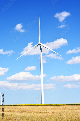 Wind turbine producing alternative energy with a clear blue sky