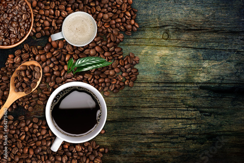 Coffee background, top view with copy space. White cup of coffee and milk, ground coffee, coffee beans on dark wooden background