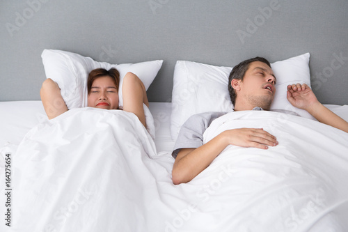 Angry Asian woman annoyed with husbands snoring photo