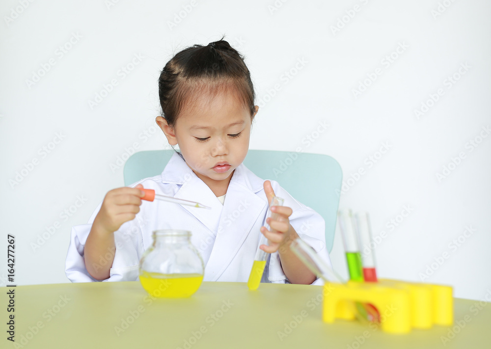 Asian child in scientist uniform holding test tube with liquid, Scientist chemistry and science education concept. Asian child in scientist uniform holding test tube with liquid, Scientist chemistry and science education concept.
