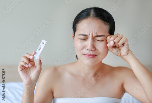 Serious young woman with a pregnancy test.