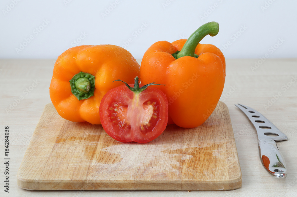 Tomatoes, pepper, knife on the board isolated on white background Tomatoes, pepper, knife on the board isolated on white background