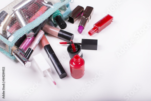 Fototapeta Naklejka Na Ścianę i Meble -  Colorful frame with various makeup products on a white background. Close up look at the mascara brushes and nail polish over a white background.