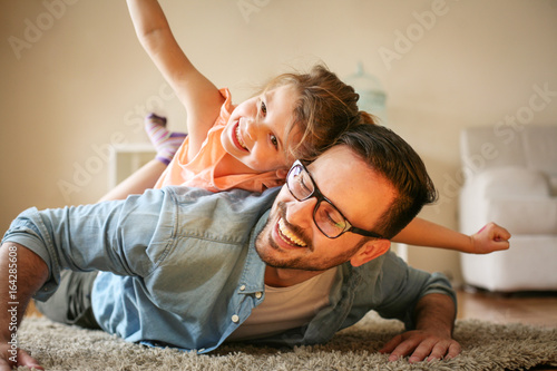 Cuadro en lienzo Happy father playing at home with his daughter.