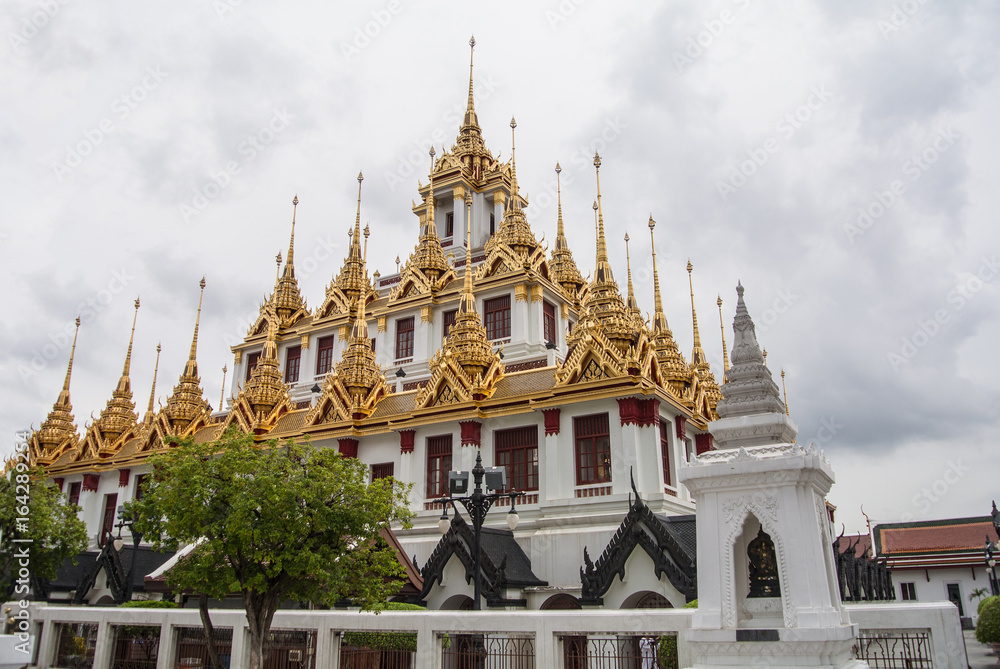 Fototapeta premium Loha Prasat Wat Ratchanatdaram in Bangkok Thailand which means iron castle or monastery is composes of five towers, of which the outer, middle and the center tower contain large black iron spires. 