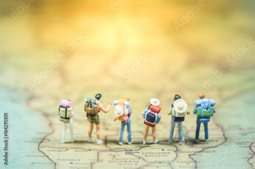 Selective focus. Miniature people : small traveler figures with backpack standing on South Africa Map / Geography of South Africa, exploring on earth background concept. photo