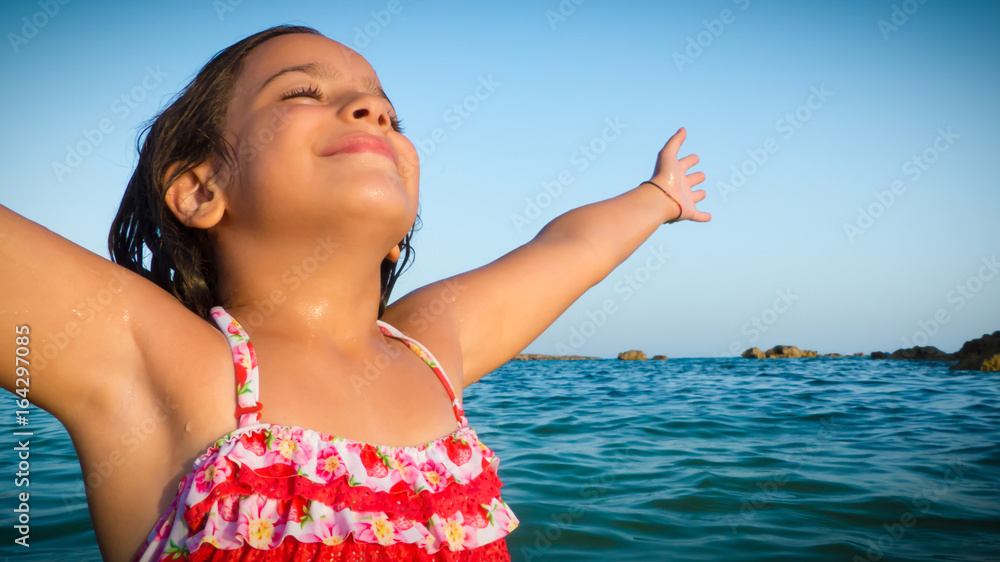 smiling, happy and serene young girl embracing sun rays