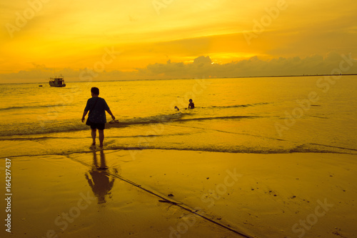 people on the beach during sunset time or silhouette