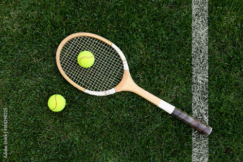 retro tennis racket on natural grass with balls. top view
