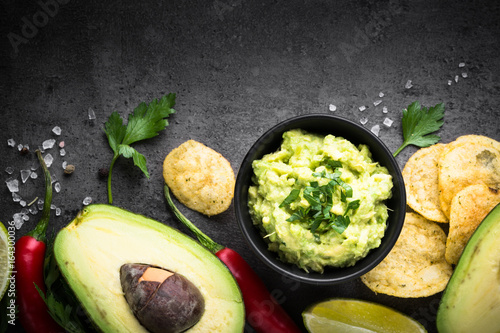 Traditional latinamerican mexican sauce guacamole on black.