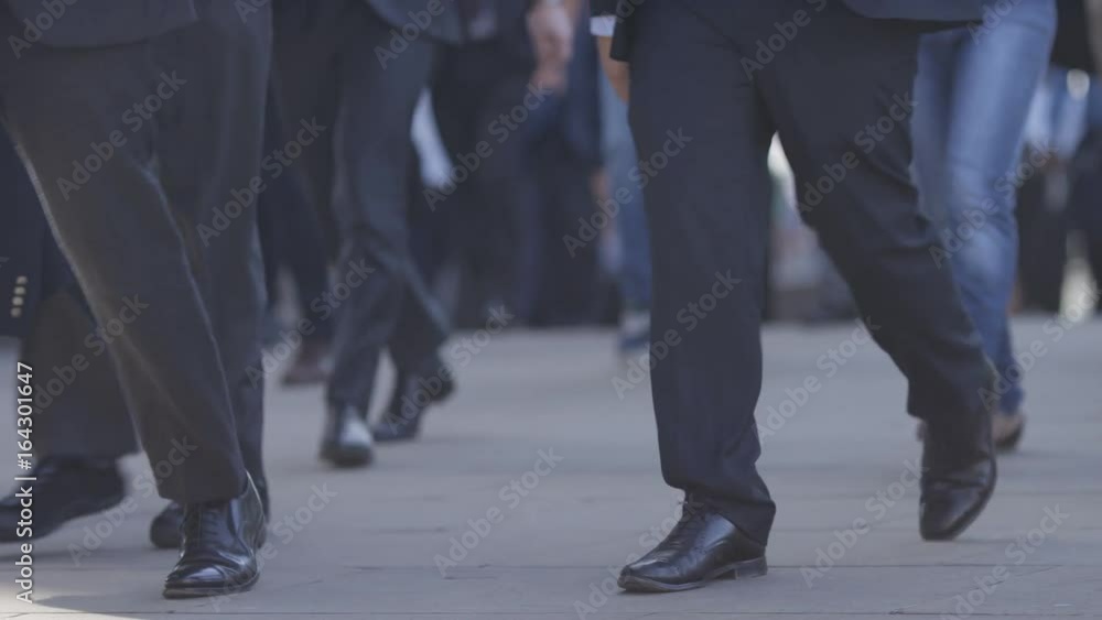 Camera pans slowly as pedestrian commuters walk to work, in slow motion Camera pans slowly as pedestrian commuters walk to work, in slow motion