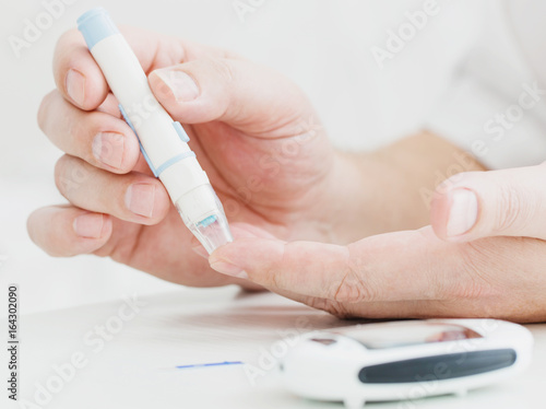 medicine  diabetes  glycemia  health care and people concept - close up of male finger with test stripe