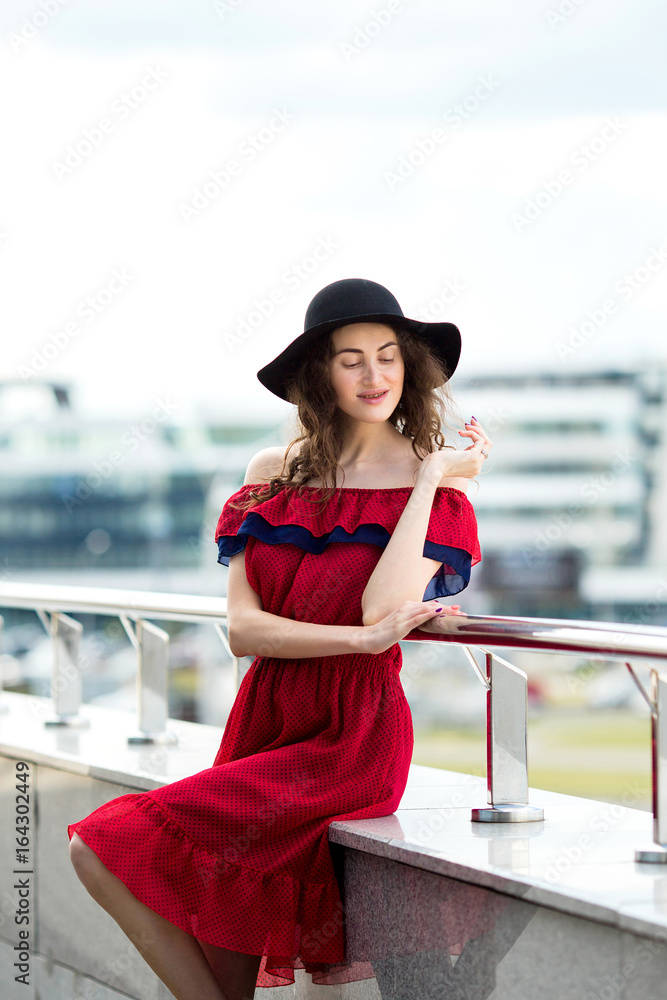 Obraz premium Beautiful girl in a hat walks around the city