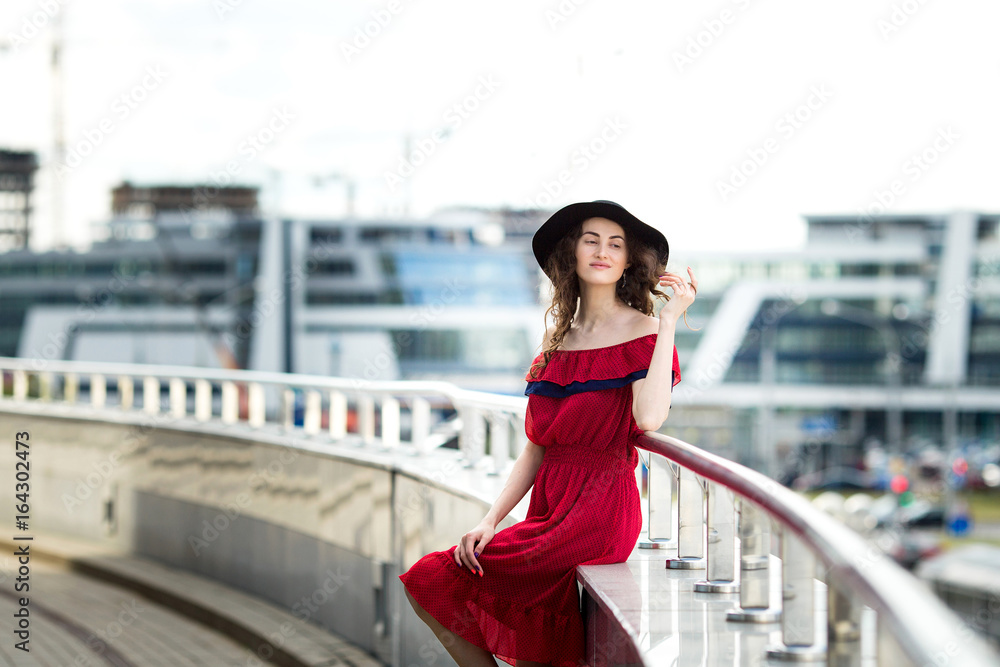 Beautiful girl in a hat walks around the city
