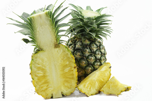 Half and whole fresh pineapple isolated on white background