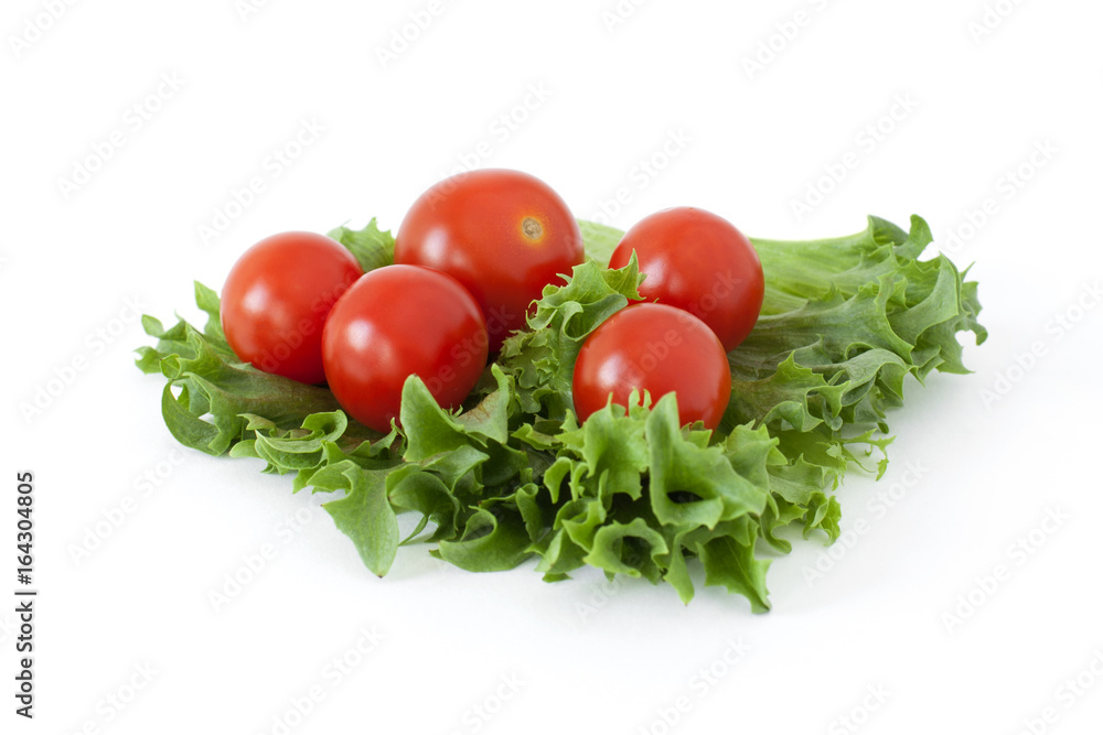 Several cherry tomatoes on fresh lettuce leaves on a white background Several cherry tomatoes on fresh lettuce leaves on a white background