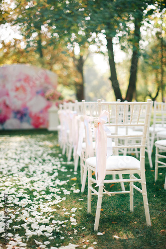 Wedding ceremony with decorations, roses petals and white chair © Vadim Pastuh