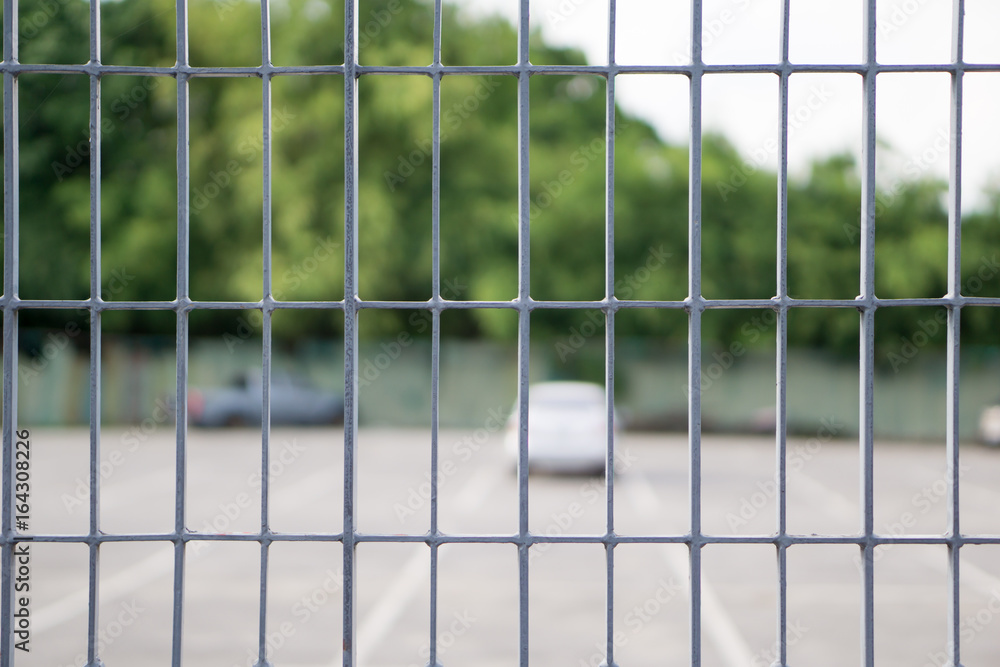 Obraz premium close up Metal grille or fence public of temporary Car Parking Stowage Barrier with blurred background. can be use as safety concept
