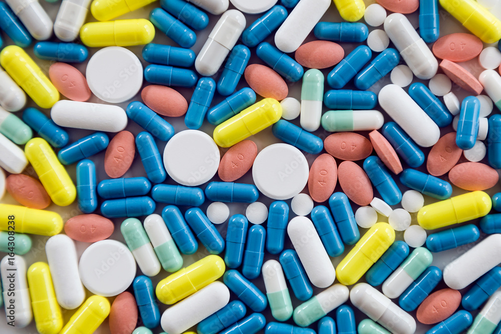 Assorted pharmaceutical medicine pills and capsules on the table. Assorted pharmaceutical medicine pills and capsules on the table.