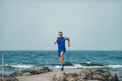 Runner young man doing his workout at coast of ocean © Volodymyr